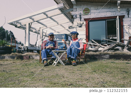 庭でくつろぐシニア夫婦の写真 112322155