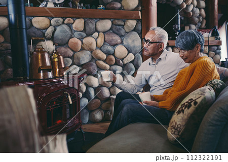 仲睦まじくソファーに座っているシニア夫婦の写真 112322191