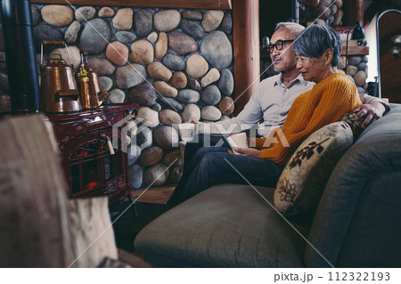 仲睦まじくソファーに座っているシニア夫婦の写真 112322193