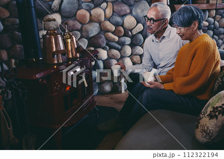 仲睦まじくソファーに座っているシニア夫婦の写真 仲睦まじくソファーに座っているシニア夫婦の写真 112322194