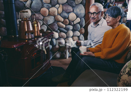 仲睦まじくソファーに座っているシニア夫婦の写真 112322199