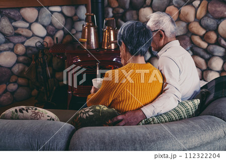 仲睦まじくソファーに座っているシニア夫婦の写真 仲睦まじくソファーに座っているシニア夫婦の写真 112322204
