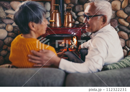 仲睦まじくソファーに座っているシニア夫婦の写真 112322231