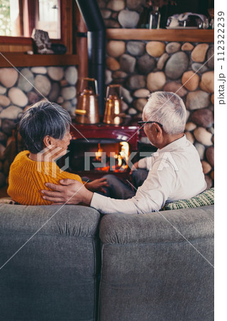 仲睦まじくソファーに座っているシニア夫婦の写真 112322239