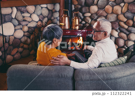 仲睦まじくソファーに座っているシニア夫婦の写真 112322241