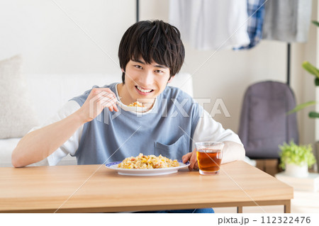 チャーハンを食べる若い男性 112322476