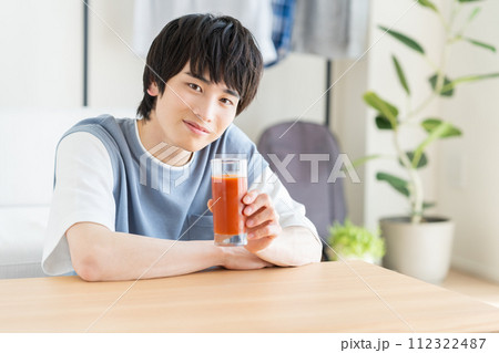 野菜ジュースを飲む若い男性 112322487