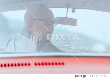 愛車に乗ってドライブをしているシニア男性の写真 愛車に乗ってドライブをしているシニア男性の写真 112322659