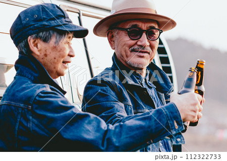 夕日を見ながら佇むシニア夫婦の写真 112322733