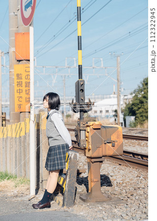 線路沿いに立つ女子高生 112322945