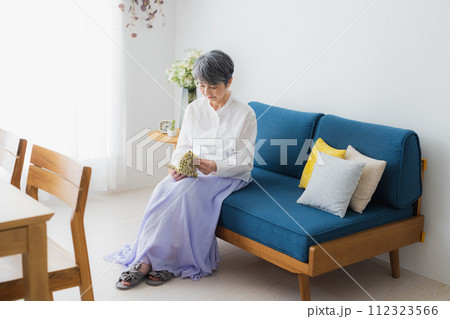 リビングで読書をするシニア女性 リビングで読書をするシニア女性 112323566