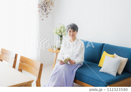 リビングで読書をするシニア女性 リビングで読書をするシニア女性 112323580