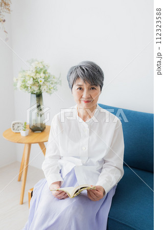 リビングで読書をするシニア女性 リビングで読書をするシニア女性 112323588