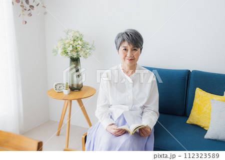 リビングで読書をするシニア女性 リビングで読書をするシニア女性 112323589