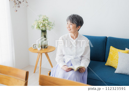 リビングで読書をするシニア女性 112323591