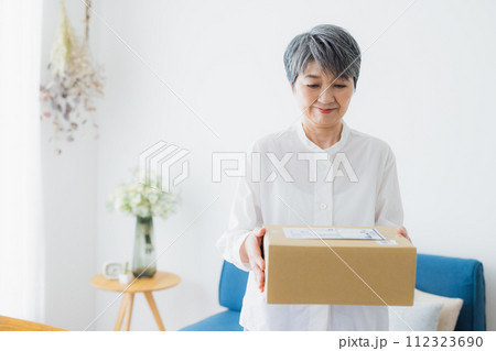 宅配を受け取るシニア女性 宅配を受け取るシニア女性 112323690