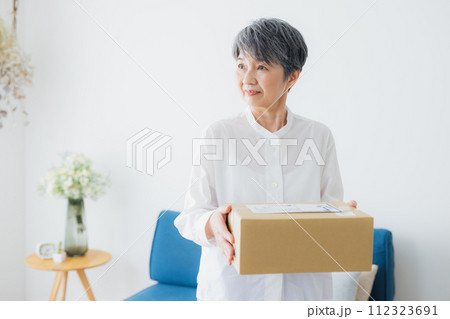 宅配を受け取るシニア女性 宅配を受け取るシニア女性 112323691