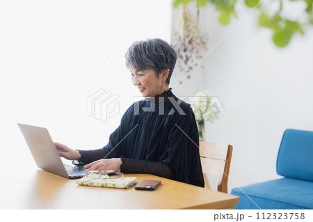 自宅でパソコンを使うシニア女性 自宅でパソコンを使うシニア女性 112323758