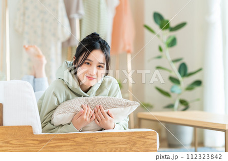 リビングでくつろぐ若い女性 リビングでくつろぐ若い女性 112323842