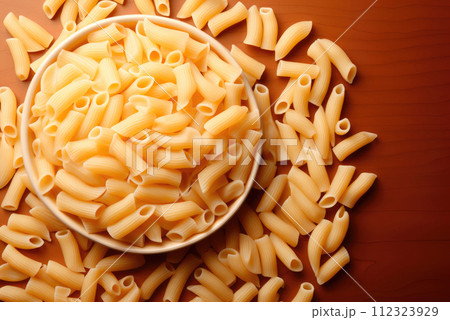Pasta on a plate and scattered on the table. 112323929