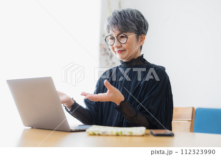 自宅でパソコンを使うシニア女性 112323990