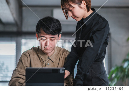 オフィスで2人ミーティングをする男女 112324044