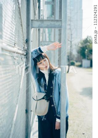 フェンスにもたれる女性 112324291