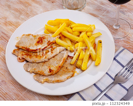 Roasted pork tenderloin served with fried potato Roasted pork tenderloin served with fried potato 112324349
