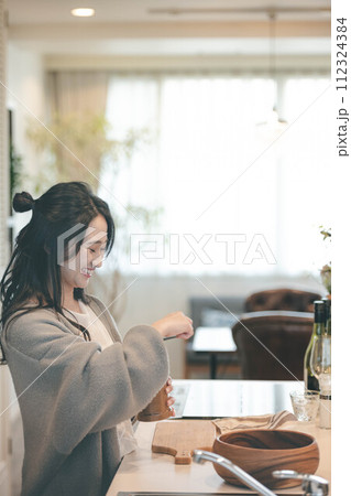 キッチンでコーヒーをいれる女性 112324384