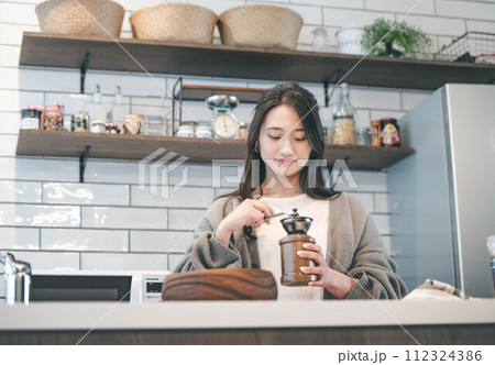 キッチンでコーヒーをいれる女性 キッチンでコーヒーをいれる女性 112324386