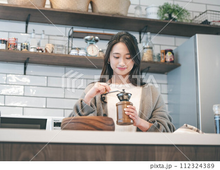 キッチンでコーヒーをいれる女性 112324389