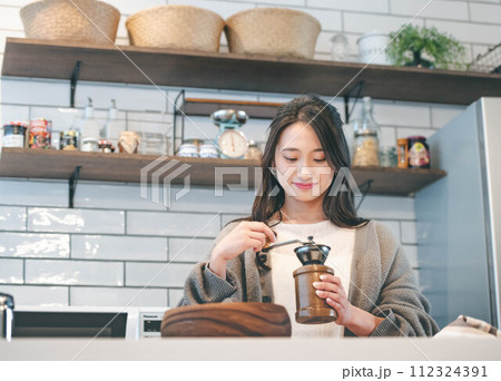 キッチンでコーヒーをいれる女性 112324391