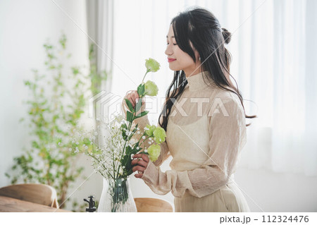 花を生ける若い女性のライフスタイルイメージ 花を生ける若い女性のライフスタイルイメージ 112324476