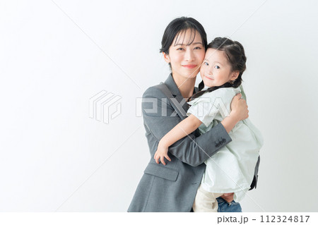 子供を抱くスーツを着たミドルのビジネスウーマン 子供を抱くスーツを着たミドルのビジネスウーマン 112324817