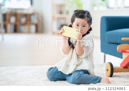 リビングでスマホで遊ぶ女の子 112324861