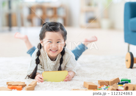 リビングでスマホで遊ぶ女の子 112324863