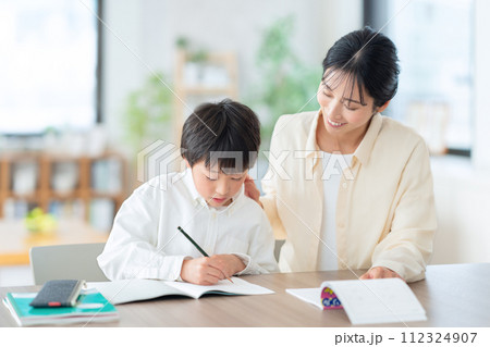 リビングで勉強する小学生と母親 リビングで勉強する小学生と母親 112324907