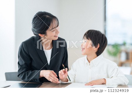 リビングで勉強する小学生と家庭教師 112324919