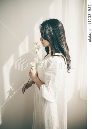 窓際に立ち花を持つ女性 窓際に立ち花を持つ女性 112324983