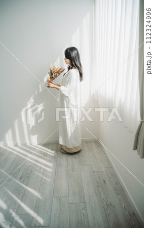 窓際に立ち花を持つ女性 窓際に立ち花を持つ女性 112324996