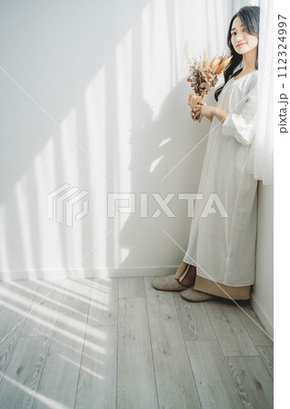 窓際に立ち花を持つ女性 窓際に立ち花を持つ女性 112324997
