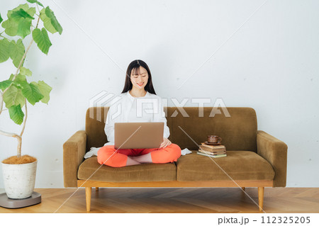 ソファでパソコンを使う女性 112325205
