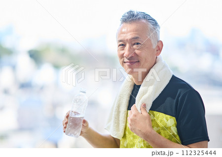 ジムで水分補給するシニア男性 112325444