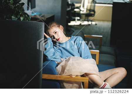 暗い部屋でソファーに座る女の子のスナップ 112326224