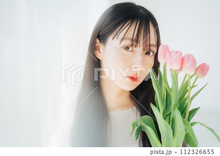 チューリップの花を持つ若い女性　 112326655