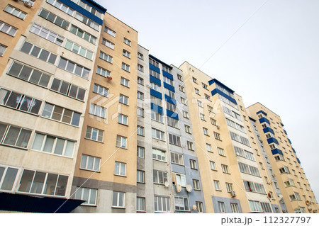 Windows of multi-storey tall building against background of sky Windows of multi-storey tall building against background of sky 112327797