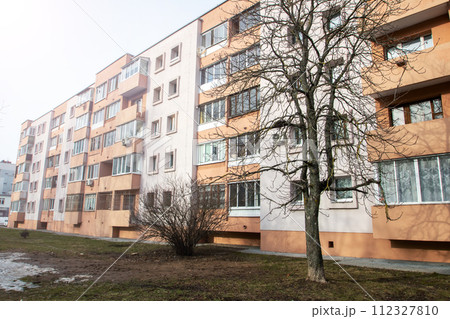 Windows of multi-storey tall building against background of sky 112327810