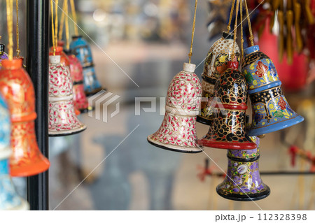 Kashmiri Papier-Mache ornaments bells for sale in the souvenir shop. Kashmiri Papier-Mache ornaments bells for sale in the souvenir shop. 112328398
