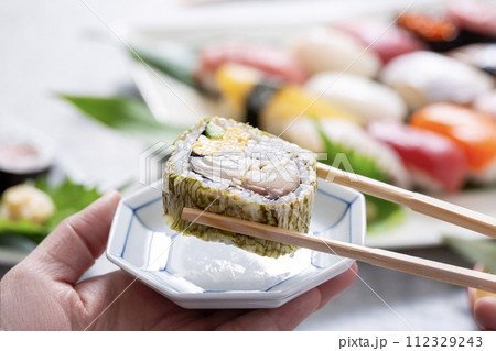 巻き寿司を食べる、箸で寿司を食べる 112329243