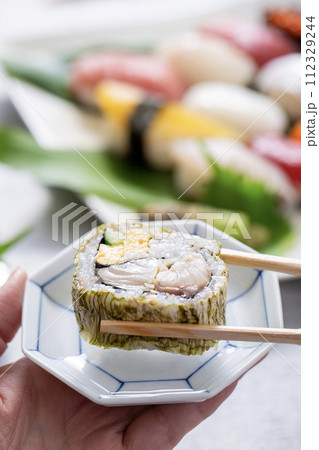 巻き寿司を食べる、箸で寿司を食べる 巻き寿司を食べる、箸で寿司を食べる 112329244